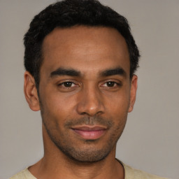 Joyful latino young-adult male with short  black hair and brown eyes