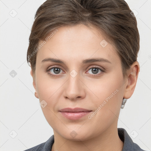 Joyful white young-adult female with short  brown hair and grey eyes