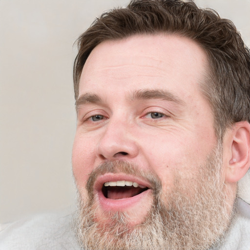 Joyful white adult male with short  brown hair and grey eyes