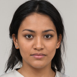 Joyful latino young-adult female with medium  brown hair and brown eyes