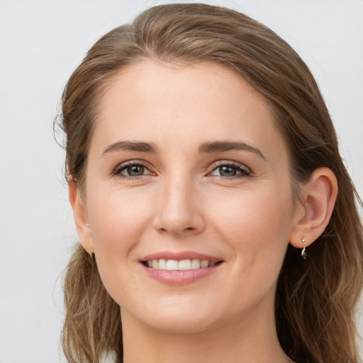 Joyful white young-adult female with long  brown hair and grey eyes