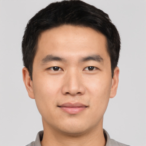 Joyful asian young-adult male with short  black hair and brown eyes