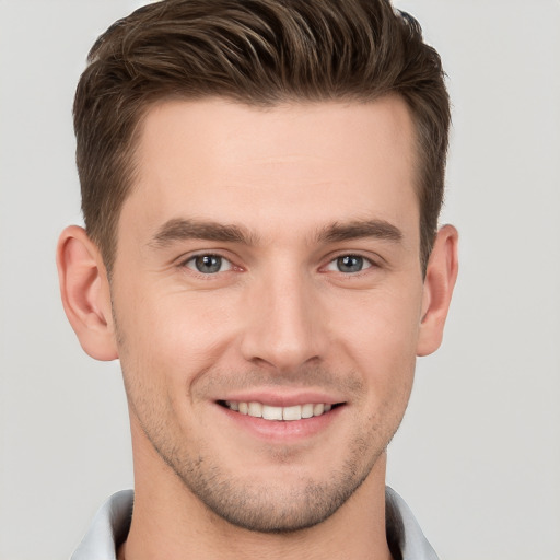 Joyful white young-adult male with short  brown hair and grey eyes