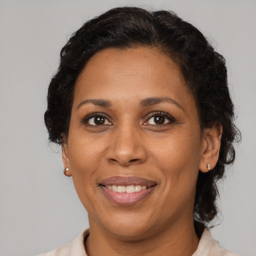 Joyful black adult female with medium  brown hair and brown eyes