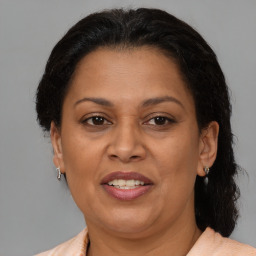 Joyful latino adult female with medium  brown hair and brown eyes