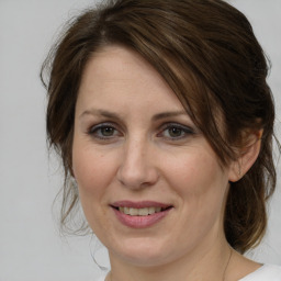 Joyful white adult female with medium  brown hair and grey eyes