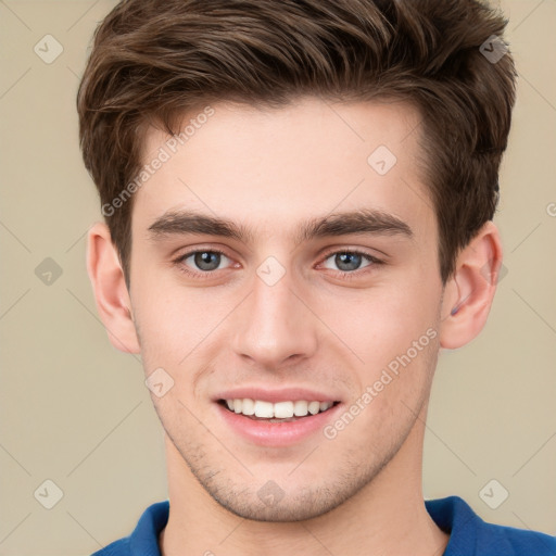 Joyful white young-adult male with short  brown hair and grey eyes