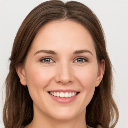 Joyful white young-adult female with long  brown hair and grey eyes