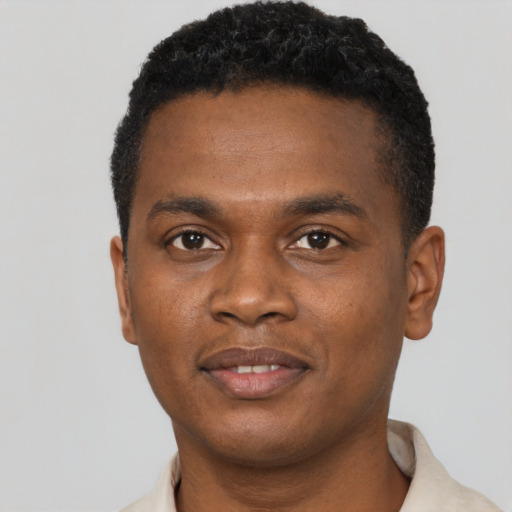 Joyful black young-adult male with short  brown hair and brown eyes