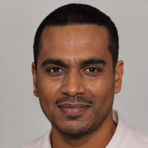 Joyful black young-adult male with short  black hair and brown eyes