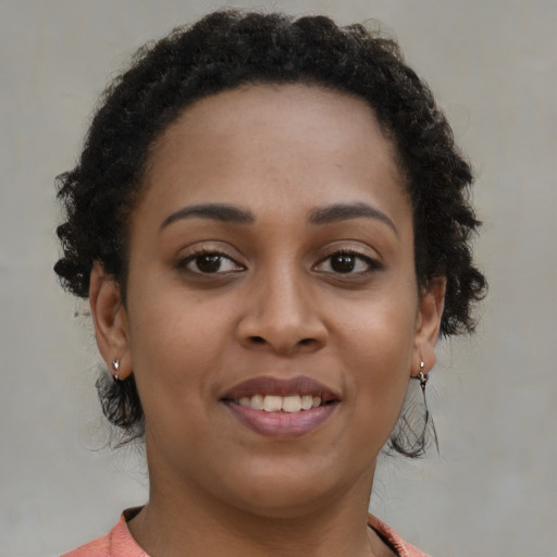 Joyful black young-adult female with short  brown hair and brown eyes