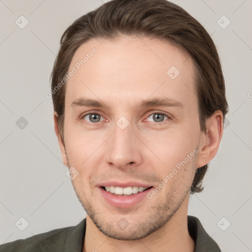 Joyful white young-adult male with short  brown hair and grey eyes