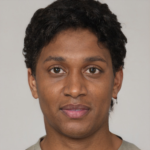 Joyful black young-adult male with short  brown hair and brown eyes