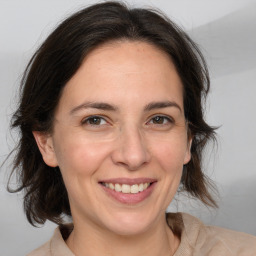 Joyful white adult female with medium  brown hair and brown eyes