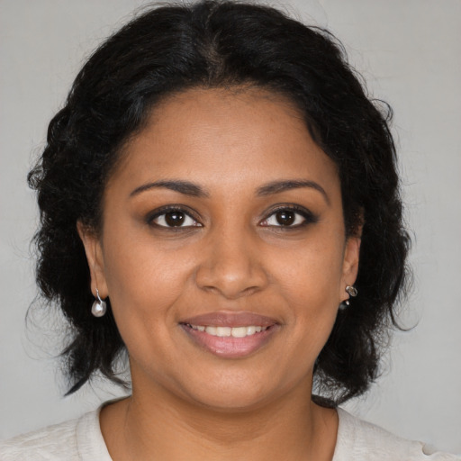 Joyful black young-adult female with medium  brown hair and brown eyes