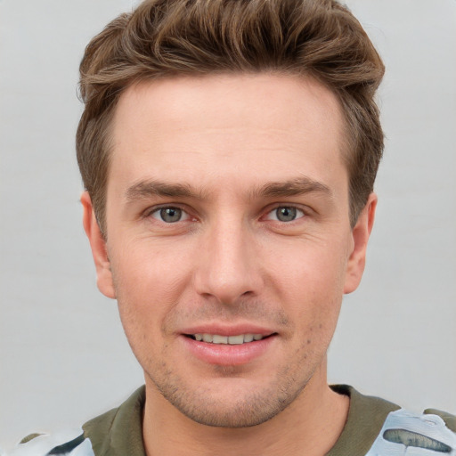 Joyful white young-adult male with short  brown hair and grey eyes