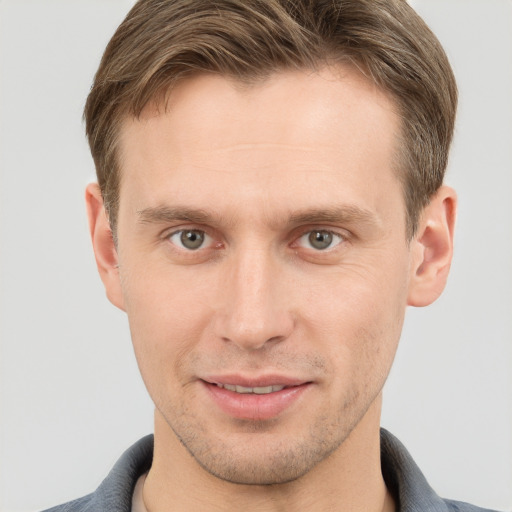 Joyful white young-adult male with short  brown hair and grey eyes