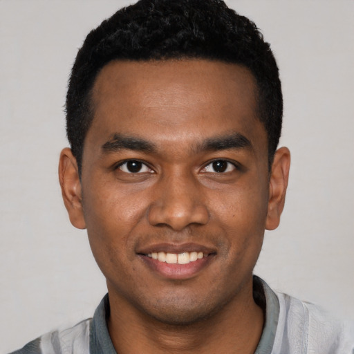 Joyful black young-adult male with short  black hair and brown eyes