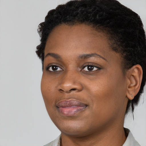 Joyful black young-adult female with short  black hair and brown eyes