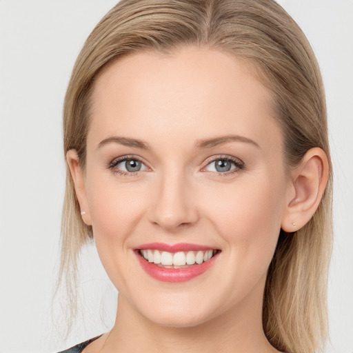 Joyful white young-adult female with long  brown hair and blue eyes