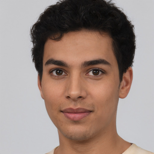 Joyful latino young-adult male with short  black hair and brown eyes