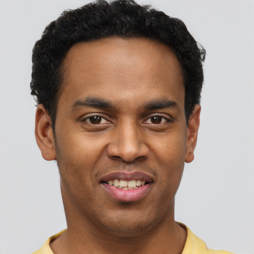 Joyful black young-adult male with short  brown hair and brown eyes