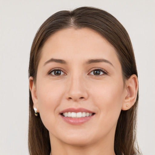 Joyful white young-adult female with long  brown hair and brown eyes