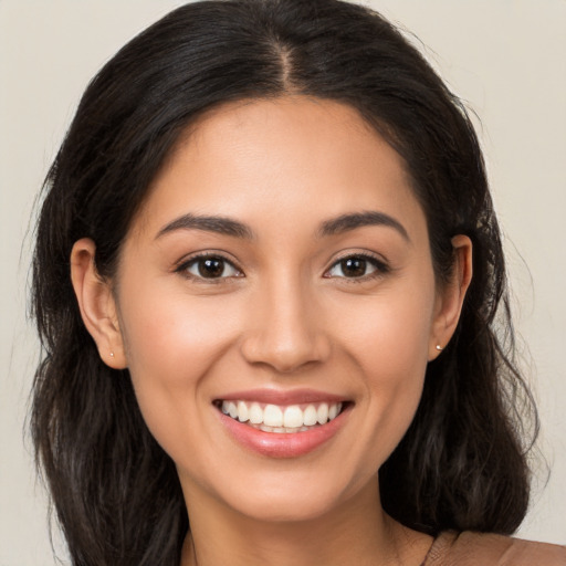 Joyful latino young-adult female with long  brown hair and brown eyes