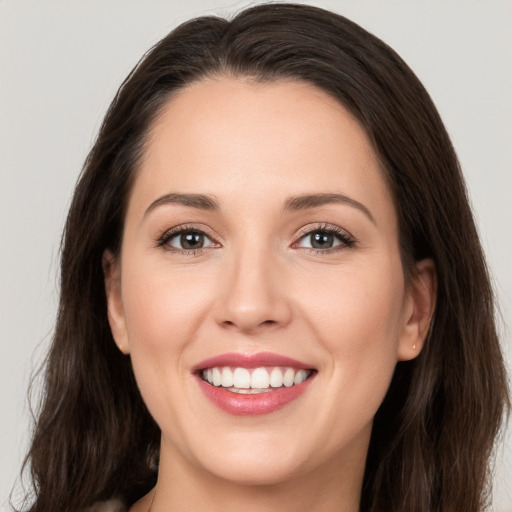 Joyful white young-adult female with long  brown hair and brown eyes