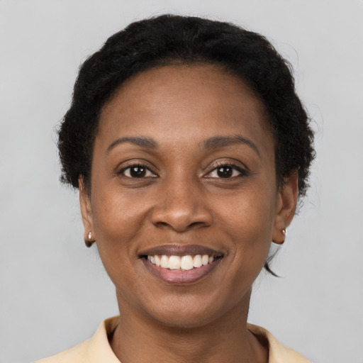 Joyful black young-adult female with short  brown hair and brown eyes