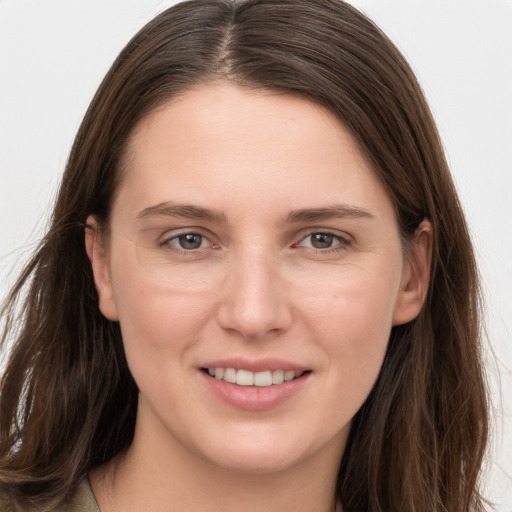 Joyful white young-adult female with long  brown hair and grey eyes