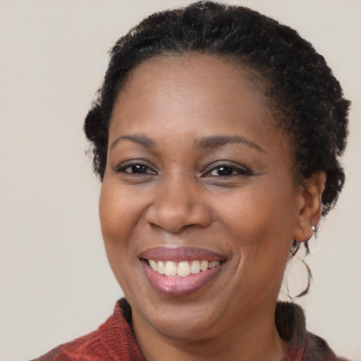 Joyful black adult female with long  brown hair and brown eyes