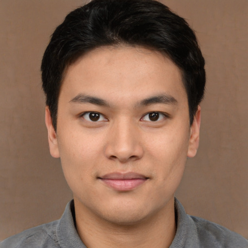 Joyful asian young-adult male with short  brown hair and brown eyes