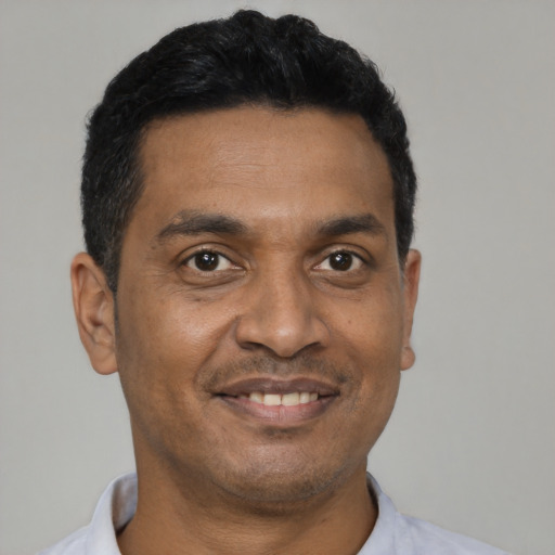 Joyful latino adult male with short  black hair and brown eyes