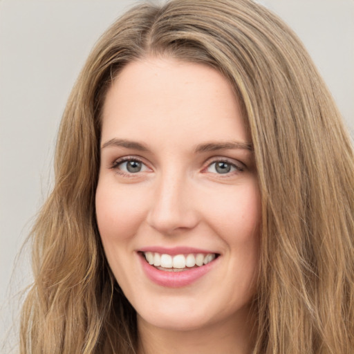 Joyful white young-adult female with long  brown hair and green eyes