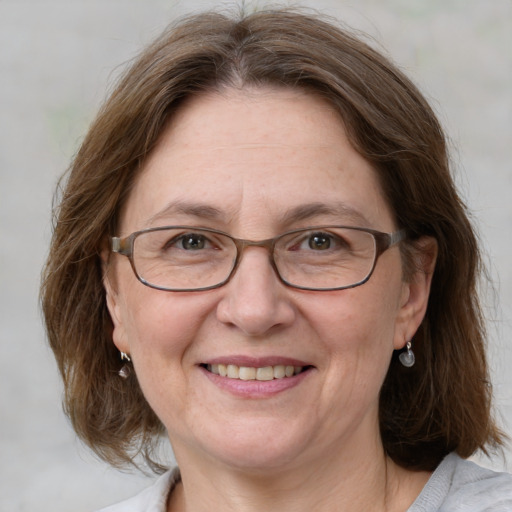 Joyful white middle-aged female with medium  brown hair and blue eyes