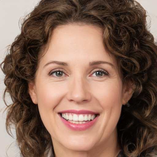 Joyful white young-adult female with medium  brown hair and green eyes