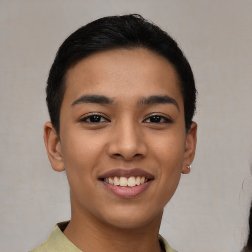 Joyful latino young-adult female with short  black hair and brown eyes