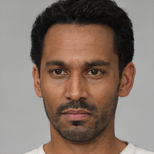 Neutral latino adult male with short  black hair and brown eyes