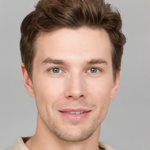 Joyful white young-adult male with short  brown hair and grey eyes