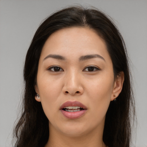 Joyful asian young-adult female with long  brown hair and brown eyes