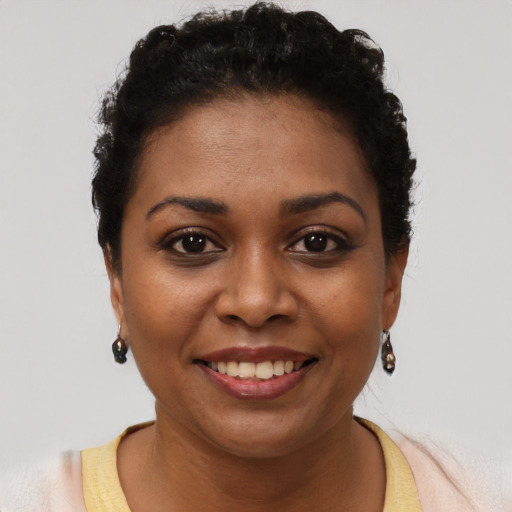 Joyful black young-adult female with short  brown hair and brown eyes