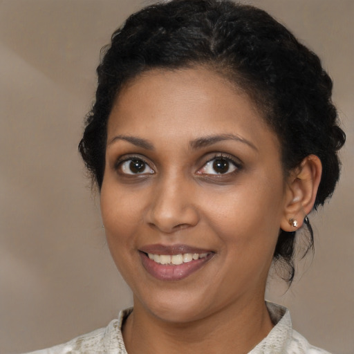 Joyful black young-adult female with short  brown hair and brown eyes