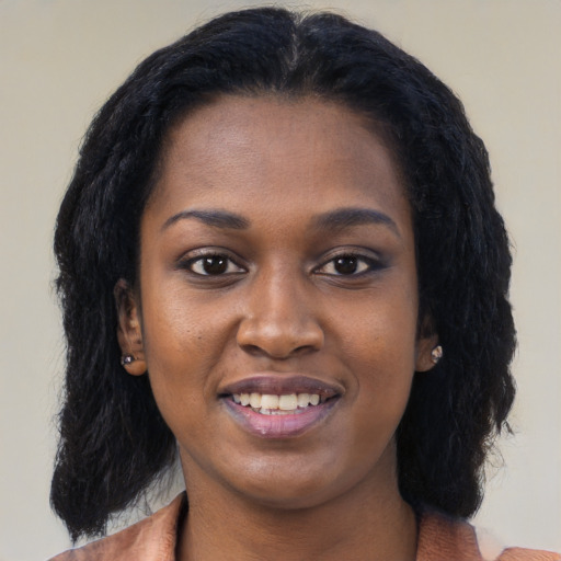 Joyful black young-adult female with long  black hair and brown eyes