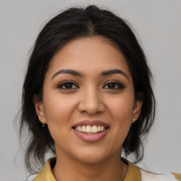 Joyful latino young-adult female with medium  brown hair and brown eyes