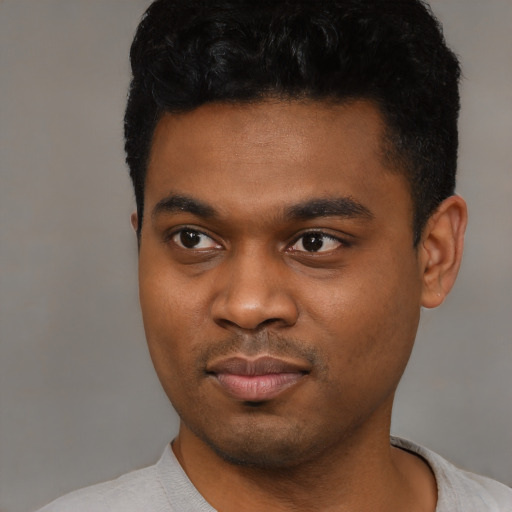 Joyful black young-adult male with short  black hair and brown eyes