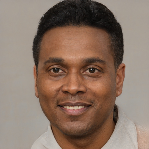 Joyful black adult male with short  black hair and brown eyes
