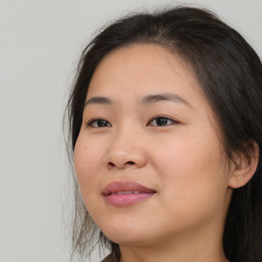 Joyful asian young-adult female with long  brown hair and brown eyes