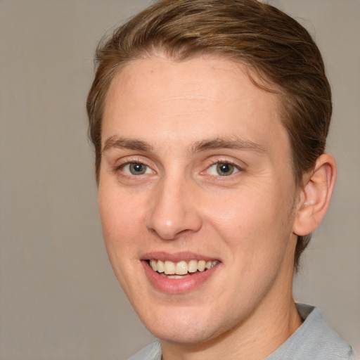 Joyful white young-adult male with medium  brown hair and grey eyes