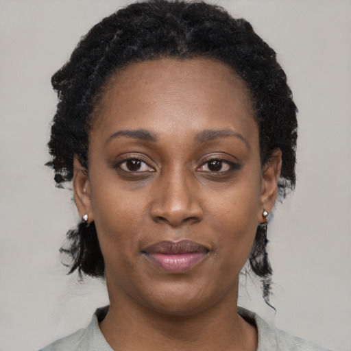 Joyful black young-adult female with short  black hair and brown eyes